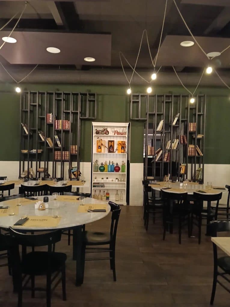 The Padellone dining room with set tables and the glass shelving unit